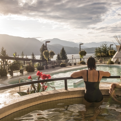 Bathers enjoying swimming at Ainsworth Hot Springs Resort with a view of Kootenay Lake.