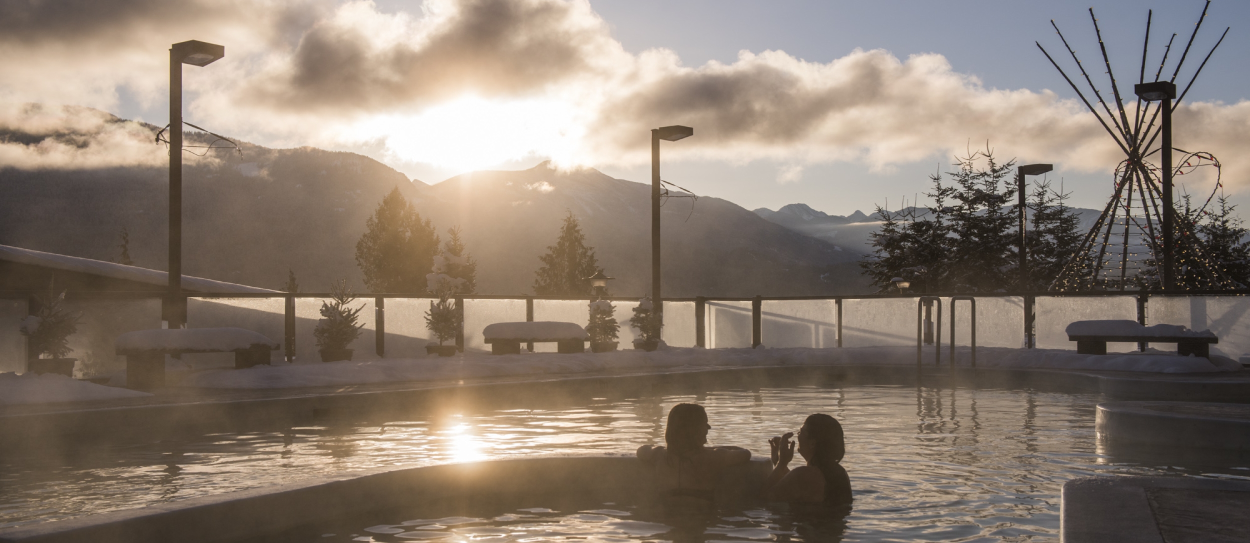 Bathers enjoying swimming at Ainsworth Hot Springs Resort with a view of Kootenay Lake.